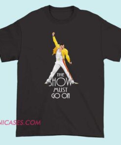 A T-shirt with the phrase "The show must go on" printed on it, featuring bold typography, theatrical or stage-inspired design elements, suitable for performers or fans of live entertainment.