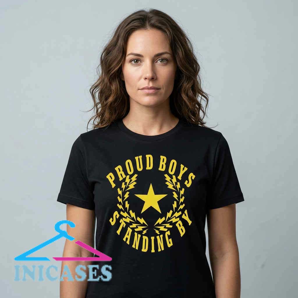 Proud Boys Standing By Logo Graphic T-Shirt Standing By logo graphic cotton T shirt featuring a bold patriotic inspired design for casual wear. Soft short sleeve tee available in black, white, and other colors with sizes S to 2XL.